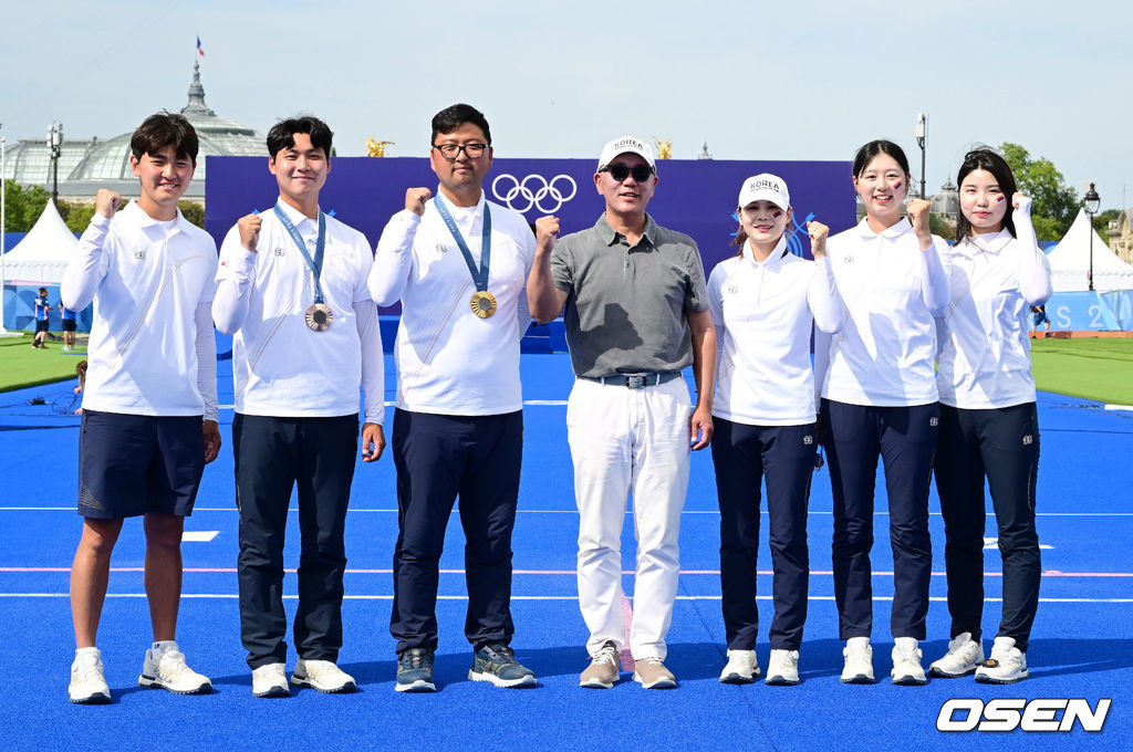 김우진(32, 청주시청)이 한국 올림픽 양궁 역사에 큰 획을 그었다. 김우진은 4일 프랑스 파리 레쟁발리드에서 열린 2024 파리 올림픽 양궁 남자 개인 결승전에서 브래디 엘리슨(미국)과 맞대결을 펼쳐 5-5 동점을 기록했다. 김우진은 슛오프까지 가는 접전끝에 엘리슨을 4.9mm 차로 잡아냈다.이로써 김우진은 역대 올림픽에서 5번째 금메달을 목에 건 최초의 한국 선수가 됐다. 여기에 파리 올림픽 3관왕을 이뤄냈다. 더불어 김우진의 금메달로 이번 한국 양국 대표팀은 양궁 전종목에서 금메달을 모두 차지하는 대기록을 작성했다.파리올림픽을 모두 마친 양궁 대표팀 김제덕, 이우석, 김우진, 정의선 현대차 회장, 전훈영, 임시현, 남수현(왼쪽부터)이 기념촬영을 하고 있다. 2024.08.04 / dreamer@osen.co.kr