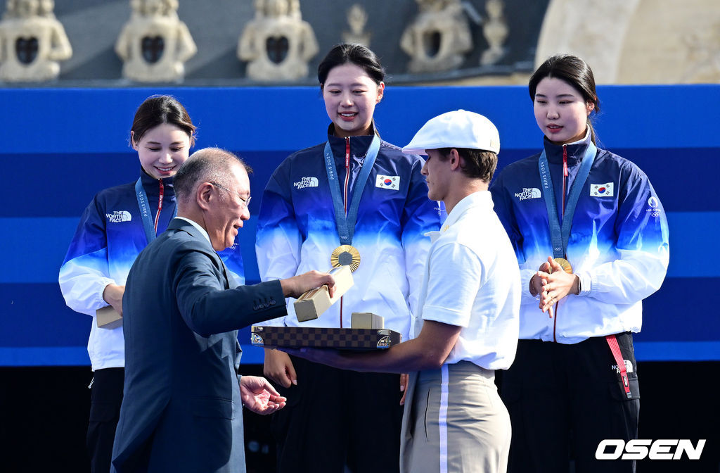 한국 여자 양궁이 올림픽 10연패 대기록을 쐈다.임시현(한국체대), 남수현(순천시청), 전훈영(인천시청)으로 구성된 한국 양궁 대표팀은 프랑스 파리 앵발리드에서 열린 ‘2024 파리올림픽’ 양궁 여자 리커브 단체전 결승서 중국(안치쉬안, 리지아만, 양사오레이) 상대로 5-4(56-53, 55-54, 51-54, 53-55, 29-27)로 승리하면서 대회 10연패를 달성했다.시상자로 참석한 정의선 현대차 회장이 양궁 임시현-남수현-전훈영에게 기념품을 전하고 있다. 2024.07.29 / dreamer@osen.co.kr