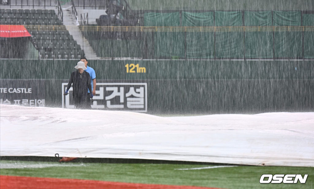 6일 부산 사직야구장에서 2024 신한 SOL 뱅크 KBO 리그 롯데 자이언츠와 NC 다이노스의 경기가 열린다. 홈팀 롯데는 윌커슨이 선발 출전하고 NC는 신민혁이 선발 출전한다.갑자기 내린 폭우로 관계자들이 방수포를 덮은 후 살펴보고 있다. 2024.08.06 / foto0307@osen.co.kr