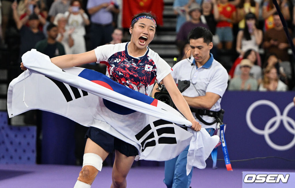 5일(한국시간) '셔틀콕 여제' 안세영(22, 삼성생명)이 꿈에 그리던 올림픽 금메달을 목에 걸었다.세계 랭킹 1위 안세영은 5일 오후(이하 한국시간) 프랑스 파리 포르트 드 라샤펠 경기장에서 열린 2024 파리올림픽 배드민턴 여자 단식 결승전에서 랭킹 9위 허빙자오(중국)를 2-0으로 꺾고 금메달을 획득 했다.  금메달을 거머쥔 안세영이 태극기를 펼치며 환호하고 있다. 2024.08.05 / dreamer@osen.co.kr