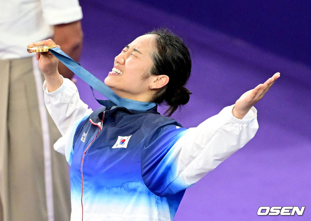 5일(한국시간) '셔틀콕 여제' 안세영(22, 삼성생명)이 꿈에 그리던 올림픽 금메달을 목에 걸었다.세계 랭킹 1위 안세영은 5일 오후(이하 한국시간) 프랑스 파리 포르트 드 라샤펠 경기장에서 열린 2024 파리올림픽 배드민턴 여자 단식 결승전에서 랭킹 9위 허빙자오(중국)를 2-0으로 꺾고 금메달을 획득 했다.  한국 안세영이 시상식에서 금메달을 들고 기뻐하고 있다. 2024.08.05 / dreamer@osen.co.kr