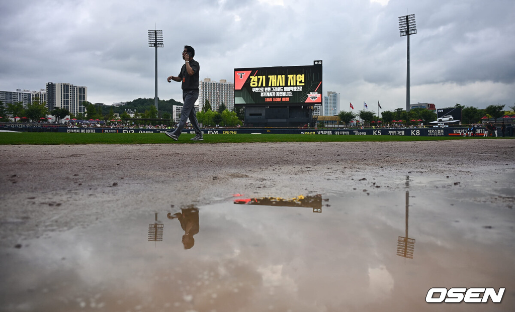 22일 광주-기아 챔피언스필드에서 2024 신한 SOL 뱅크 KBO 리그 KIA 타이거즈와 롯데 자이언츠의 경기가 열린다.홈팀 KIA는 김도현이 선발 출전하고 방문팀 롯데는 반즈가 선발 출전한다.경기를 앞두고 갑자기 내리는 소나기에 김시진 경기감독관이 경기장 상태를 파악하고 있다. 2024.08.22 / foto0307@osen.co.kr