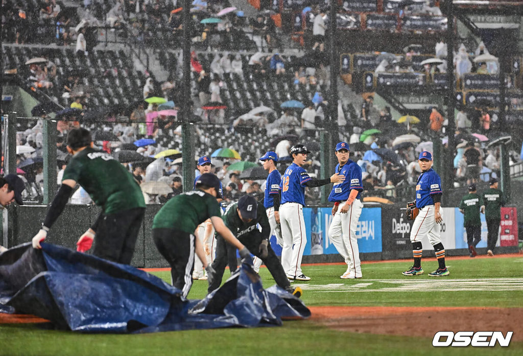 29일 부산 사직야구장에서 2024 신한 SOL 뱅크 KBO 리그 롯데 자이언츠와 한화 이글스의 경기가 열렸다. 홈팀 롯데는 윌커슨이 선발 출전하고 한화는 바리아가 선발 출전했다.갑자기 내린 폭우에 선수들이 경기를 중단하고 들어가고 있다. 2024.08.29 / foto0307@osen.co.kr