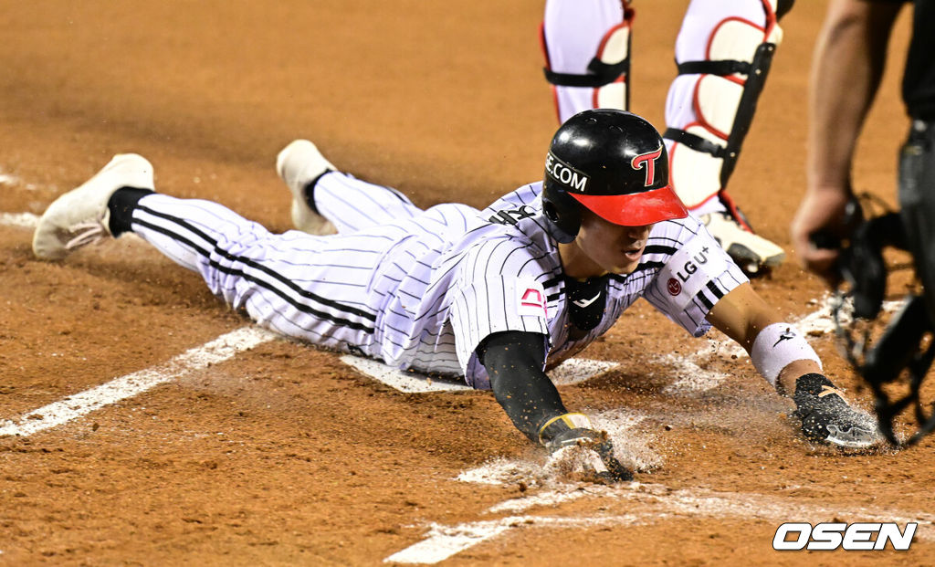 11일 서울 잠실야구장에서 ‘2024 신한 SOL뱅크 KBO 포스트시즌’ 준플레이오프 5차전 LG 트윈스와 KT 위즈의 경기가 열렸다.LG는 임찬규, KT는 엄상백을 선발 투수로 내세웠다.1회말 1사 1루에서 LG 신민재가 오스틴의 선제 1타점 적시 2루타에 홈에서 슬라이딩 세이프되고 있다. 2024.10.11 / jpnews@osen.co.kr