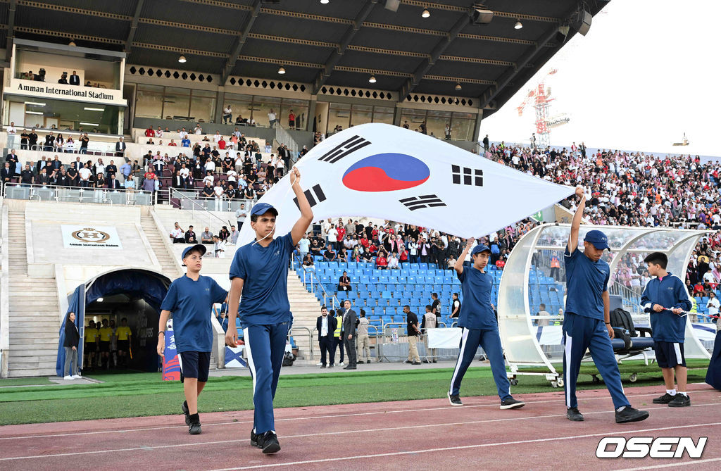 10일 오후(한국시간) 요르단 암만 국제경기장에서 2026 국제축구연맹(FIFA) 북중미월드컵 아시아 3차 예선 B조 3차전 한국과 요르단의 경기가 열렸다.다득점에서 앞선 요르단(1승1무, 4골)이 조 선두, 한국(1승1무, 3골)은 2위다. 한국이 조 선두를 탈환하려면 반드시 요르단을 잡아야 한다. 2024.10.10 /spjj@osen.co.kr주장 손흥민(32, 토트넘 홋스퍼)이 없어도, 연이어 부상 악재가 닥쳐도 충분히 강했다. 홍명보호가 요르단 원정에서 완승을 거두며 2023 카타르 아시안컵 설욕에 성공했다. 홍명보 감독이 지휘하는 축구대표팀은 10일 오후 11시(한국시간) 요르단 암만국제경기장에서 개최된 ‘2026 북중미 월드컵 아시아지역 3차 예선 3차전’에서 요르단을 2-0으로 꺾었다.경기 요원들이 태극기를 들고 입장하고 있다. 2024.10.10 /spjj@osen.co.kr