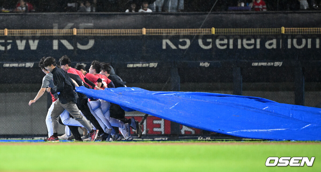 21일 광주 기아챔피언스필드에서 2024 신한 SOL뱅크 KBO 한국시리즈 1차전 KIA 타이거즈와 삼성 라이온즈의 경기가 열렸다.KIA는 네일, 삼성은 원태인을 선발 투수로 내세웠다.우천으로 경기 개시가 지연되는 가운데 KIA 그라운드키퍼가 방수포를 걷고 있다. 2024.10.21 / jpnews@osen.co.kr