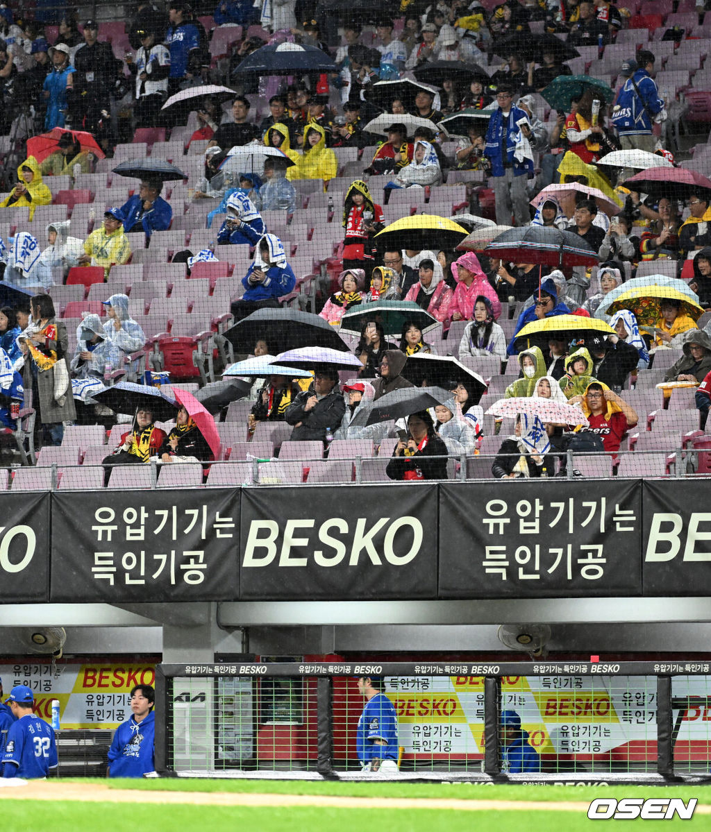 21일 광주 기아챔피언스필드에서 2024 신한 SOL뱅크 KBO 한국시리즈 1차전 KIA 타이거즈와 삼성 라이온즈의 경기가 열렸다.KIA는 네일, 삼성은 원태인을 선발 투수로 내세웠다.경기장에 비가 내리가 관중들이 우산을 쓰고 시작을 기다리고 있다. 2024.10.21 / sunday@osen.co.kr