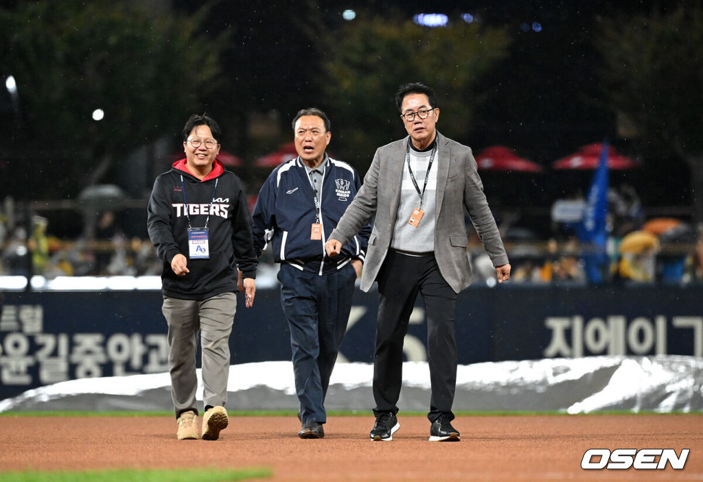 21일 광주 기아챔피언스필드에서 2024 신한 SOL뱅크 KBO 한국시리즈 1차전 KIA 타이거즈와 삼성 라이온즈의 경기가 열렸다.KIA는 네일, 삼성은 원태인을 선발 투수로 내세웠다.경기장에 비가 내리가 임채섭, 김시진 경기감독관이 그라운드를 살피고 있다. 2024.10.21 / sunday@osen.co.kr