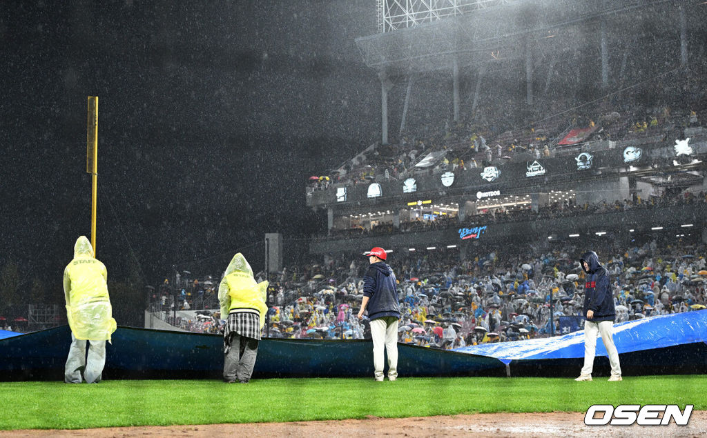 21일 광주 기아챔피언스필드에서 2024 신한 SOL뱅크 KBO 한국시리즈 1차전 KIA 타이거즈와 삼성 라이온즈의 경기가 열렸다.KIA는 네일, 삼성은 원태인을 선발 투수로 내세웠다.6회초 많은 비로 경기가 중단된 가운데 경기장 요원들이 방수포를 깔고 있다. 2024.10.21 / sunday@osen.co.kr