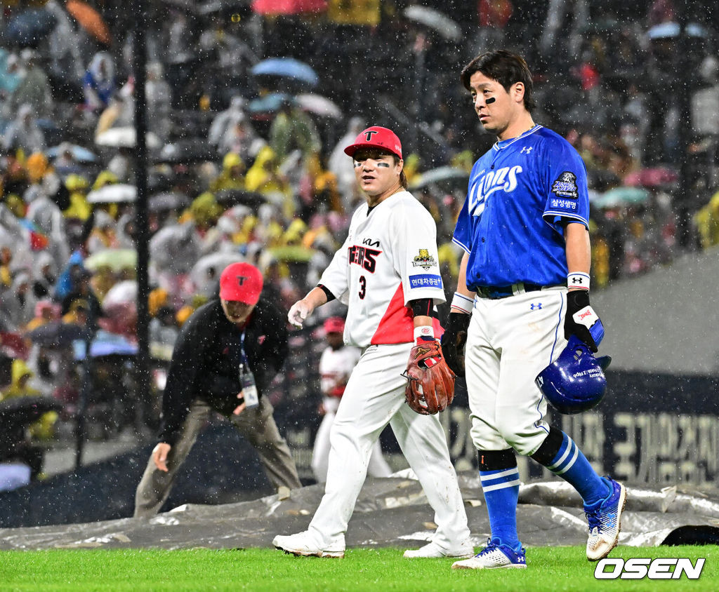 21일 광주 기아챔피언스필드에서 2024 신한 SOL뱅크 KBO 한국시리즈 1차전 KIA 타이거즈와 삼성 라이온즈의 경기가 열렸다.KIA는 네일, 삼성은 원태인을 선발 투수로 내세웠다.6회초 우천으로 경기가 중단되며 KIA 김선빈과 삼성 강민호가 이야기를 나누며 더그아웃으로 향하고 있다. 2024.10.21 / jpnews@osen.co.kr