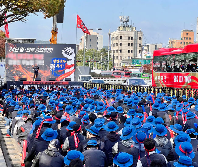 지난 달 28일 현대트랜시스 노조원 등 1,000여 명이 현대차∙기아 양재사옥 앞 3개 차선을 막은 채 대형 무대와 초대형 스피커를 설치하고, 모욕적인 표현이 담긴 현수막과 보행자를 위협할 수 있는 대형 깃발 등을 동원해 대대적인 집회를 열고 있다. 현대트랜시스 노조는 작년 회사 영업이익의 2배에 달하는 과도한 성과급을 요구하며 파업을 한달 가까이 이어가고 있다. /독자제공. 