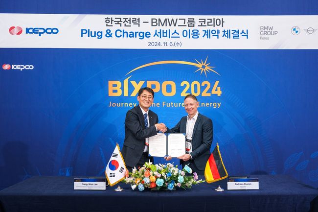 안드레아스 스툼 BMW 그룹 R&D 센터 코리아 총괄(오른쪽)과 이상원 한국전력 에너지신사업처장(왼쪽)이 PnC 충전 서비스 이용 계약 체결식에서 기념촬영을 하고 있다.