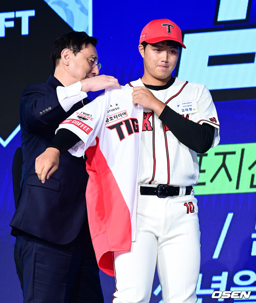 11일 오후 서울 잠실 롯데호텔 월드에서 2025 KBO 신인 드래프트가 열렸다.2025 KBO 신인 드래프트는 전면 드래프트 방식으로 진행된다. 지명은 1라운드부터 11라운드까지 이뤄지며, 2023년도 구단 순위의 역순인 키움-한화-삼성-롯데-KIA-두산-NC-SSG-KT-LG 순서로 실시된다.덕수고 김태형이 KIA에 1라운드 지명되며 심재학 단장이 유니폼을 전달하고 있다. 2024.09.11 / jpnews@osen.co.kr