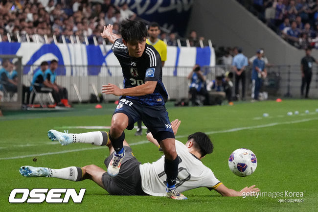 SAITAMA, JAPAN - SEPTEMBER 05: Takefusa Kubo of Japan (L) goes past Liu Yang of China (R) during the FIFA World Cup Asian 3rd Qualifier Group C match between Japan and China at Saitama Stadium on September 05, 2024 in Saitama, Japan. (Photo by Koji Watanabe/Getty Images)