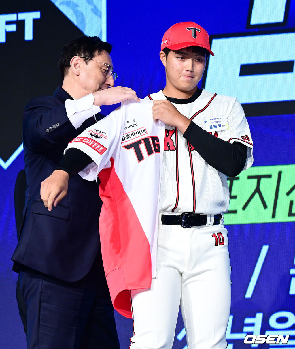 11일 오후 서울 잠실 롯데호텔 월드에서 2025 KBO 신인 드래프트가 열렸다.2025 KBO 신인 드래프트는 전면 드래프트 방식으로 진행된다. 지명은 1라운드부터 11라운드까지 이뤄지며, 2023년도 구단 순위의 역순인 키움-한화-삼성-롯데-KIA-두산-NC-SSG-KT-LG 순서로 실시된다.덕수고 김태형이 KIA에 1라운드 지명되며 심재학 단장이 유니폼을 전달하고 있다. 2024.09.11 / jpnews@osen.co.kr