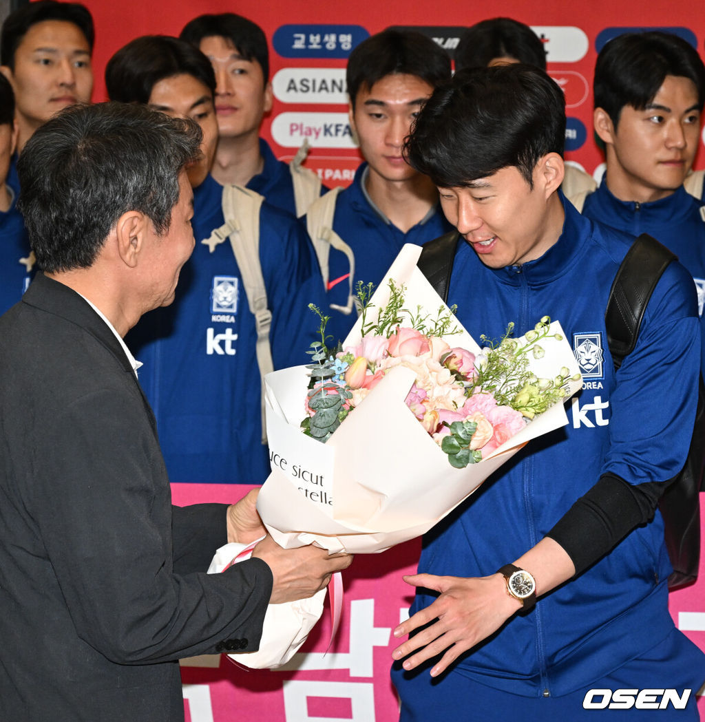 월드컵 11회 연속 본선 진출에 성공한 한국 축구 국가대표팀이 6일 인천국제공항을 통해 이라크에서 귀국했다.한국은 6일 새벽(한국 시간) 이라크 원정서 2-0 승리로 승점 19(5승 4무)점을 확보하면서 월드컵 11회 연속 본선 진출을 확정지었다.정몽규 대한축구협회장(왼쪽)이 축구대표팀 손흥민에게 꽃다발을 전달하고 있다. 2025.06.06 /cej@osen.co.kr