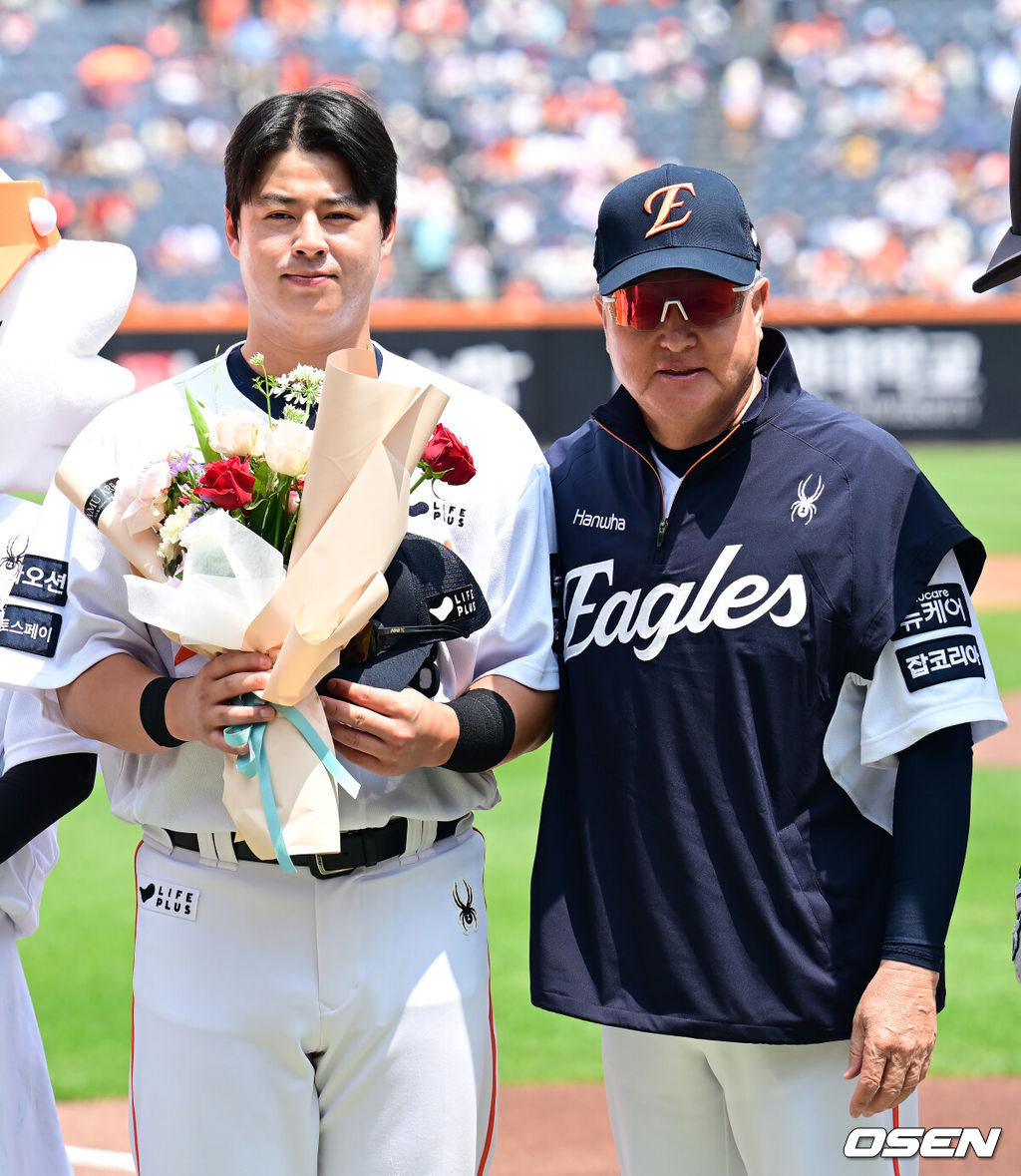 한화 노시환이 김경문 감독에게 역대 108번째 통산 100홈런을 기념 꽃다발을 전달 받은 뒤 기념촬영을 하고 있다. 2025.06.03 / ksl0919@osen.co.kr