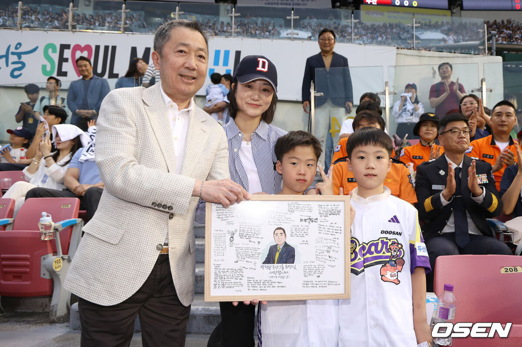 24일 서울 잠실야구장에서 ‘2025 신한 SOL Bank KBO리그’ 두산 베어스와 SSG 랜더스의 경기가 열렸다.홈팀 두산은 최원준, 방문팀 SSG은 미치 화이트를 선발로 내세웠다.소방가족의 날 행사를 맞아 두산 박정원 구단주가 지난 2018년 순직한 故심문규 소방장 유가족에게 AI 복원 가족사진과 쌍둥이 자녀에게 선물을 전하고 있다. 2025.06.24 / dreamer@osen.co.kr