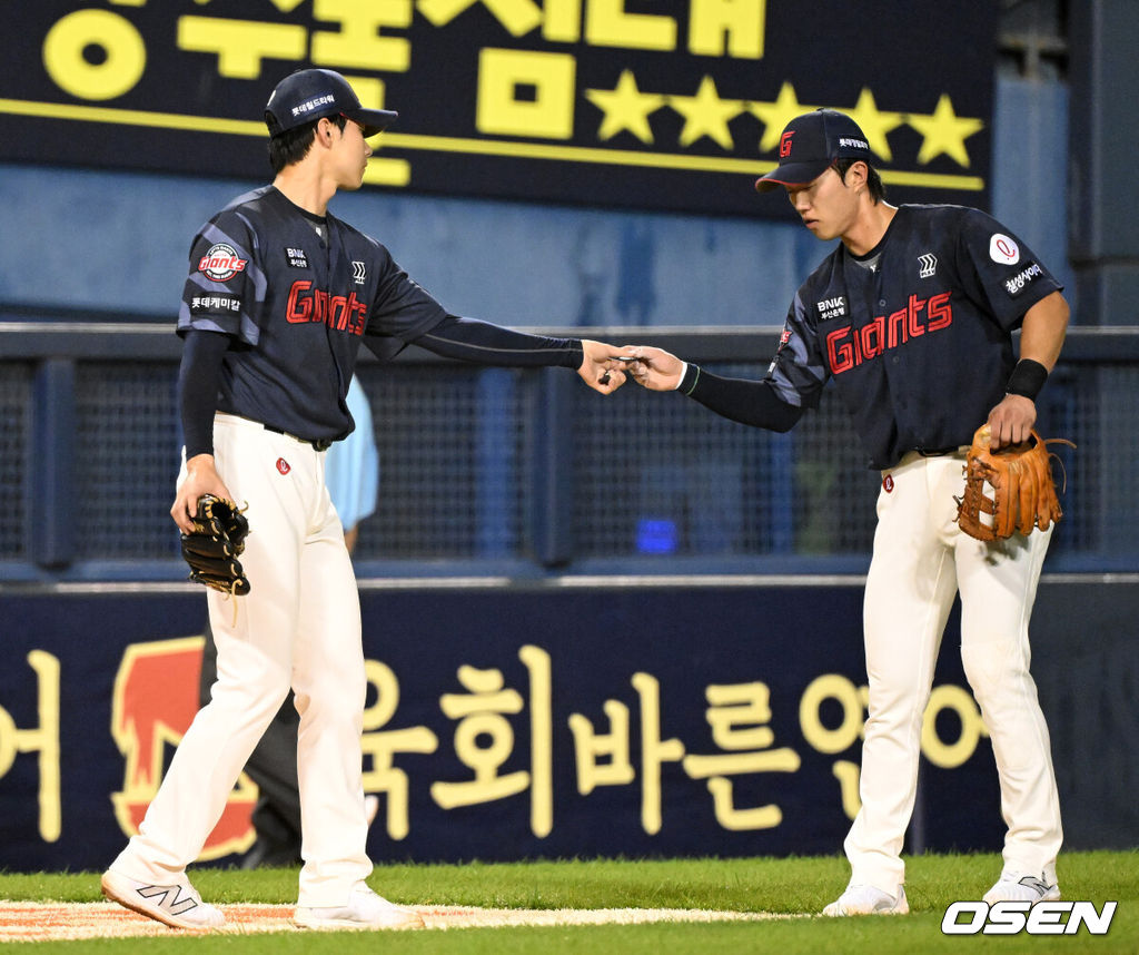 19일 오후 서울 잠실야구장에서 2025 신한 SOL Bank KBO리그 LG 트윈스와 롯데 자이언츠의 경기가 열렸다.LG는 에르난데스, 롯데는 데이비슨을 선발 투수로 내세웠다.8회말 1사 1루에서 롯데 홍민기가 마운드를 내려가며 전민재에게 피치컴을 건네고 있다.  2025.07.19 /sunday@osen.co.kr