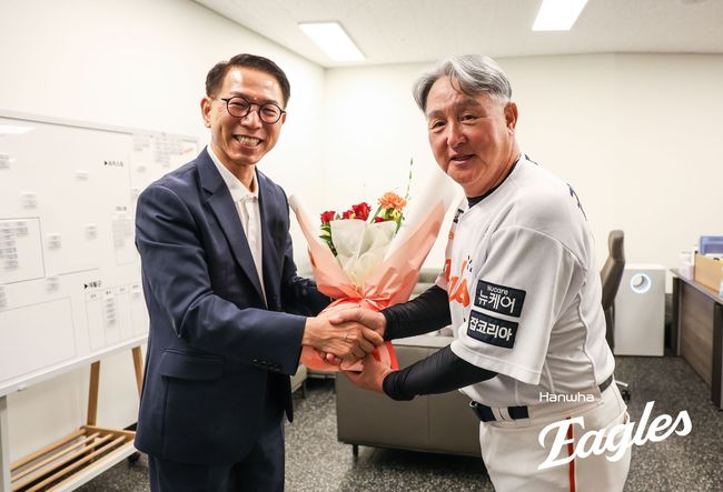 한화 김경문 감독(오른쪽)이 박종태 대표이사로부터 부임 100승 기념 축하 꽃다발을 받고 있다. /한화 이글스 제공