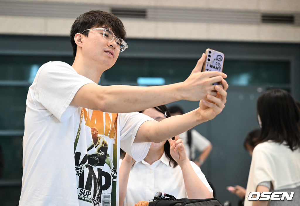 한국 남자 농구 대표팀 이현중, 여준석, 박지훈이 2025 국제농구연맹(FIBA) 아시아컵을 마치고 16일 인천공항을 통해 귀국했다.안준호 감독이 이끄는 한국 남자 농구 대표팀은 지난 14일 (한국시간) 사우디아라비아 제다의 킹 압둘라 스포츠 시티에서 열린 2025년 국제농구연맹(FIBA) 아시아컵 8강전에서 중국에 71-79로 패하며 4강 진출에 실패했다.대표팀 이현중이 팬과 기념촬영을 하고 있다. 2025.08.16 /cej@osen.co.kr