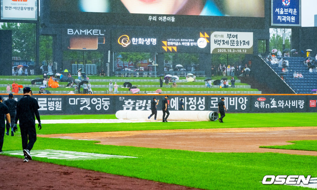 28일 오후 대전 한화생명볼파크에서 2025 신한 SOL Bank KBO리그 한화 이글스와 LG 트윈스의 경기가 열릴 예정이지만 그라운드에 비가 내리고 있다.프로야구 LG 트윈스의 정규리그 우승 확정이 걸린 대전 경기가 폭우 속에서도 개최 준비를 한다. 경기 개시 시간을 1시간 늦춰 들어갈 예정이다. 빗줄기가 다시 굵어지자 치워졌던 대형 방수포가 다시 깔리고 있다. 2025.09.28 / rumi@osen.co.kr