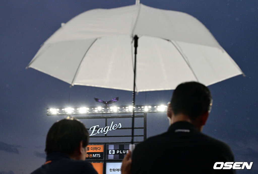 17일 오후 대전 한화생명볼파크에서 2025 신한 SOL Bank KBO리그 포스트시즌 플레이오프 1차전 한화 이글스와 삼성 라이온즈의 경기가 열렸다.한화는 폰세, 삼성은 가라비토를 선발 투수로 내세웠다.비가 내리는 가운데 관계자들이 그라운드를 바라보고 있다. 2025.10.17 /jpnews@osen.co.k