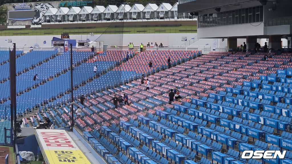 한화 이글스 관계자들이 21일 플레이오프 3차전이 열리는 대구 삼성라이온즈파크 1루측 관중석에 오렌지색 우비와 오렌지색 수건을 배포하고 있다. /orange@osen.co.k