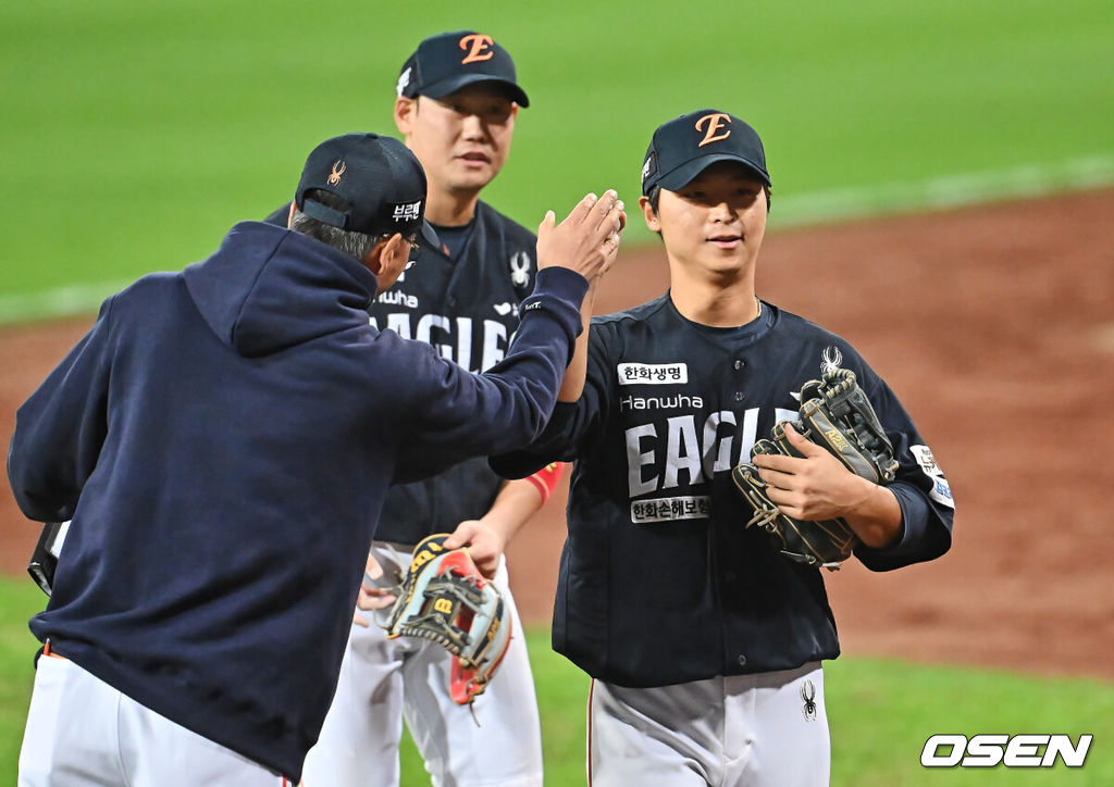 21일 대구 삼성라이온즈파크에서 2025 신한 SOL뱅크 KBO 플레이오프 삼성 라이온즈와 한화 이글스의 3차전 경기가 열렸다. 홈팀 삼성은 후라도가, 방문팀 한화는 류현진이 선발 투수로 출전했다.한화 이글스 최인호가 3회말 무사 1루 삼성 라이온즈 류지혁의 우익수 플라이 아웃때 강민호를 1루에서 포스 아웃시키고 이닝 교체하며 동료들과 하이파이브를 하고 있다. 2025.10.21 / foto0307@osen.co.kr