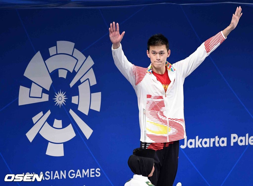 쑨양(27·중국)이 아시안게임 남자 자유형 1500m 3연패를 달성하며 4관왕에 올랐다. 쑨양은 24일 오후 인도네시아 자카르타의 겔로라 붕 카르노(GBK) 아쿠아틱 센터에서 열린 2018 자카르타-팔렘방 아시안게임 남자 자유형 1500m 결선서 14분58초53을 기록했다.중국 쑨양이 시상대에 올라 손을 흔들고 있다./sunday@osen.co.kr
