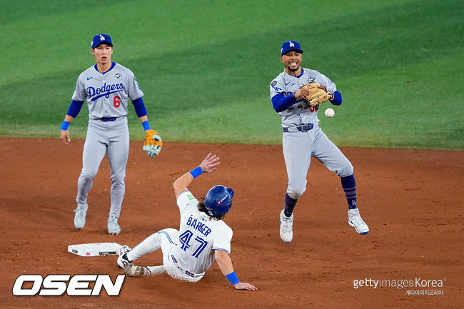 [사진] LA 다저스 유격수 무키 베츠(오른쪽)가 월드시리즈 7차전 연장 11회 토론토 알레한드로 커크의 유격수 땅볼 때 직접 2루를 밟은 뒤 1루로 송구하고 있다. 다저스 2루수 김혜성(왼쪽)이 베츠의 송구를 바라바고 있다.  ⓒGettyimages(무단전재 및 재배포 금지)