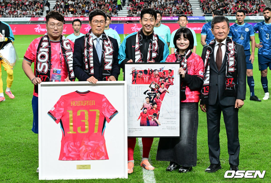 한국 축구가 안방에서 '남미 강호' 파라과이를 물리치며 사상 최초의 2026 국제축구연맹(FIFA) 북중미 월드컵 포트 2 확보에 청신호를 켰다.한국 축구대표팀은 14일 오후 8시 서울월드컵경기장에서 열린 A매치 친선 경기에서 파라과이를 2-0으로 제압했다. 지난 10일 일본 원정에서 2-2로 비기고 온 파라과이는 한국에 덜미를 잡히며 10월 아시아 투어를 1무 1패로 마감하게 됐다.브라질전 출전으로 한국 축구 A매치 최다 출전(137경기) 금자탑을 쌓은 손흥민이 이번에도 선발로 나서며 138경기로 기록을 늘렸다. 손흥민이 최다 출전 기념식을 하고 있다. 2025.10.14 /cej@osen.co.kr