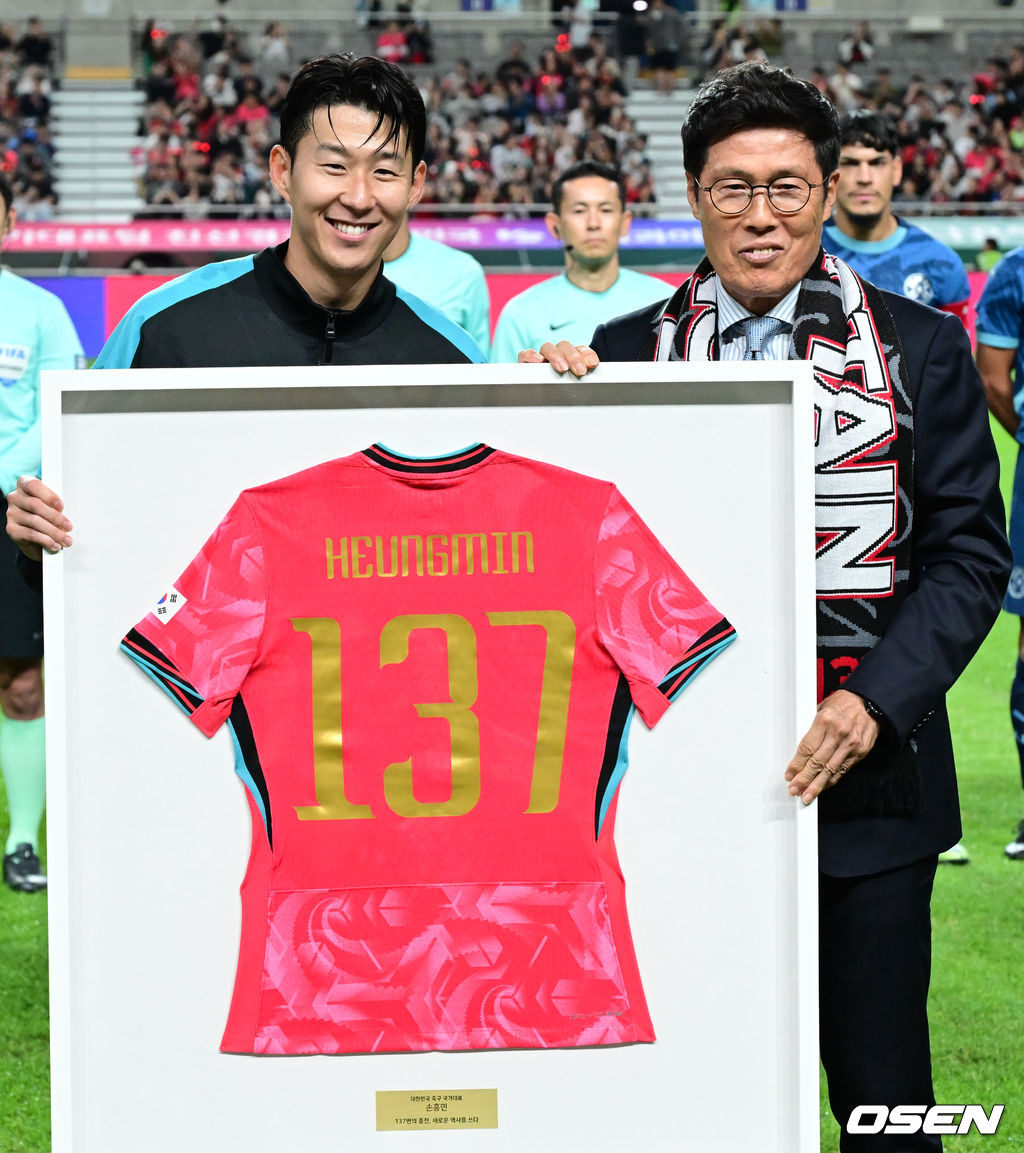 한국 축구가 안방에서 '남미 강호' 파라과이를 물리치며 사상 최초의 2026 국제축구연맹(FIFA) 북중미 월드컵 포트 2 확보에 청신호를 켰다.한국 축구대표팀은 14일 오후 8시 서울월드컵경기장에서 열린 A매치 친선 경기에서 파라과이를 2-0으로 제압했다. 지난 10일 일본 원정에서 2-2로 비기고 온 파라과이는 한국에 덜미를 잡히며 10월 아시아 투어를 1무 1패로 마감하게 됐다.경기 전 차범근 전 감독이 경기장을 찾아 손흥민에게 기념 유니폼을 직접 전달하고 있다. 2025.10.14 /cej@osen.co.kr
