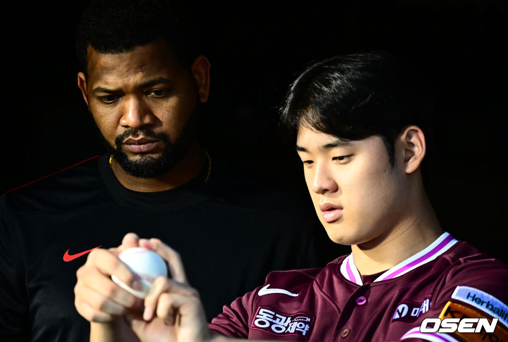 키움 히어로즈 라울 알칸타라가 정현우에게 그립을 설명하고 있다. /OSEN DB