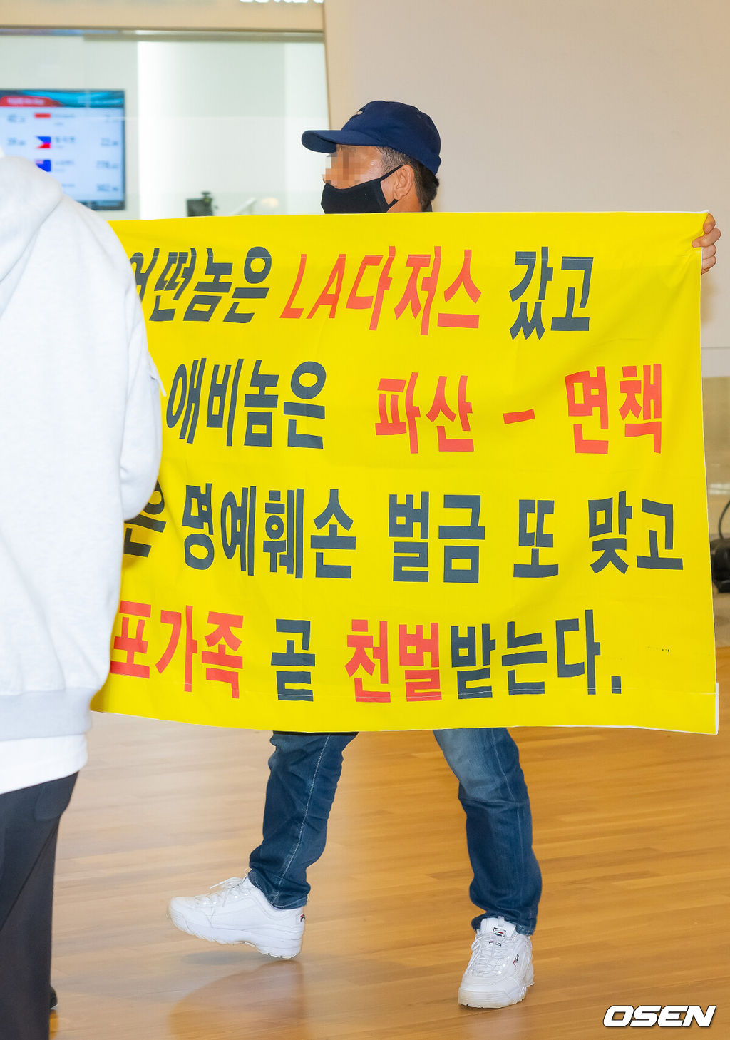 미국프로야구 메이저리그(MLB) LA 다저스의 김혜성이 6일 오후 인천국제공항을 통해 귀국했다.김혜성은 메이저리그 진출 첫 해 우승반지를 거머쥐는 영광을 누렸다. 한국인 메이저리거 야수로는 역대 최초로 월드시리즈 우승반지를 차지한 김혜성은 올해 71경기 출전, 타율 0.280(161타수 45안타), 3홈런 17타점 19득점, 13도루(1실패), 출루율 0.314 장타율 0.385, OPS 0.699의 기록으로 정규시즌을 마무리했다.김혜성이 입국장 앞에서 인터뷰를 할때 한 남성이 비난 현수막을 펼치고 있다. 2025.11.06 /rumi@osen.co.kr