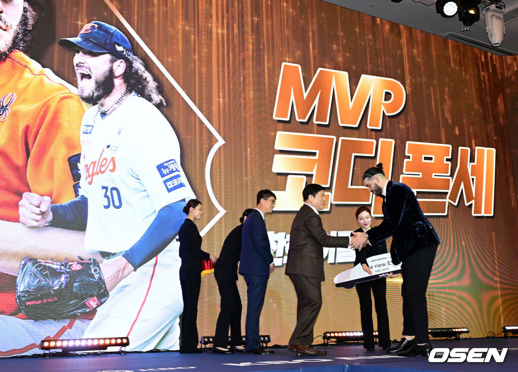 24일 오후 서울 잠실 롯데호텔 월드 크리스탈볼룸에서 ‘2025 신한 SOL뱅크 KBO 시상식’이 열렸다.예상대로였다. 한화 이글스 코디 폰세(31)가 2025시즌 MVP로 선정됐다. 폰세는 기자단 투표 124표 중 96표(76%)를 얻어 23표에 그친 르윈 디아즈(삼성)를 제치고 수상했다. SSG 앤더슨, 삼성 후라도, NC 라일리, KT 안현민, 롯데 레이예스가 각각 1표식 얻었다. 폰세는 부상으로 The Kia EV6 전기차를 부상으로 받았다. MVP를 수상한 한화 폰세가 KBO 허구연 총재의 축하를 받고 있다. 2025.11.24 /jpnews@osen.co.kr