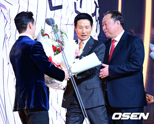 [OSEN=지형준 기자] 9일 오후 서울 송파구 잠실동 롯데호텔 월드에서 2025 신한은행 SOL 뱅크 KBO 골든글러브 시상식이 열렸다.KBO 골든글러브 시상식은 포지션별 최고의 선수를 가리는 자리로 올 시즌의 대미를 장식하는 자리다. LG 신민재가 2루수 부문 골든글러브를 수상하며 염경엽 감독, 차명석 단장의 축하를 받고 있다. 2025.12.09 /jpnews@osen.co.kr