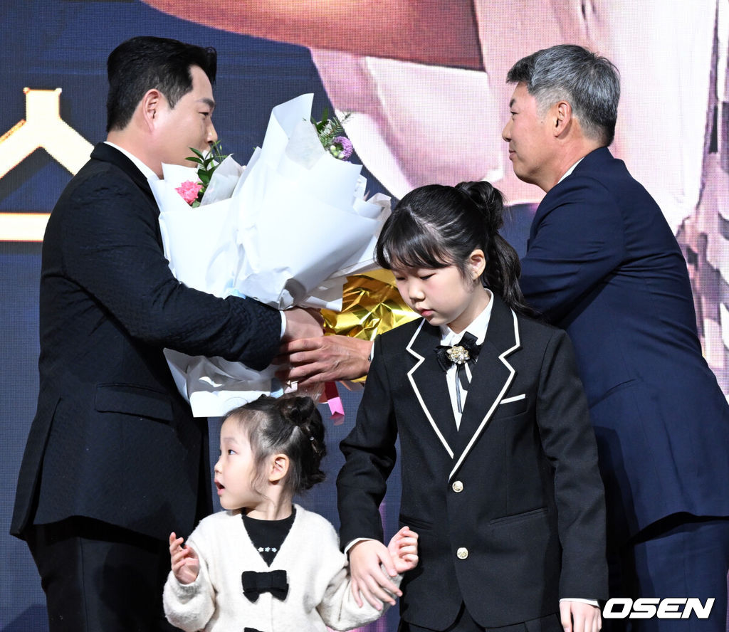 9일 오후 서울 송파구 잠실동 롯데호텔 월드에서 2025 신한은행 SOL 뱅크 KBO 골든글러브 시상식이 열렸다.KBO 골든글러브 시상식은 포지션별 최고의 선수를 가리는 자리로 올 시즌의 대미를 장식하는 자리다. 포수 부문 수상한 두산 양의지가 두산 김원형 감독과 두 딸에게 꽃다발을 받고 있다. 2025.12.09 /cej@osen.co.kr