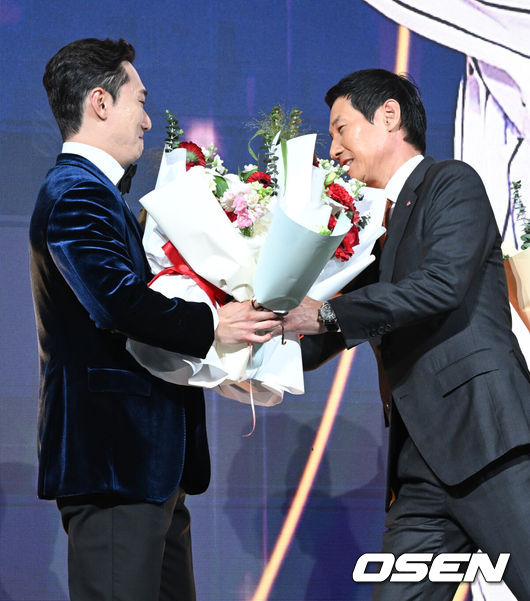 [OSEN=조은정 기자] 9일 오후 서울 송파구 잠실동 롯데호텔 월드에서 2025 신한은행 SOL 뱅크 KBO 골든글러브 시상식이 열렸다.KBO 골든글러브 시상식은 포지션별 최고의 선수를 가리는 자리로 올 시즌의 대미를 장식하는 자리다. 2루수 부문을 수상한 LG 신민재가 염경엽 감독에게 꽃다발을 받고 있다. 2025.12.09 /cej@osen.co.kr