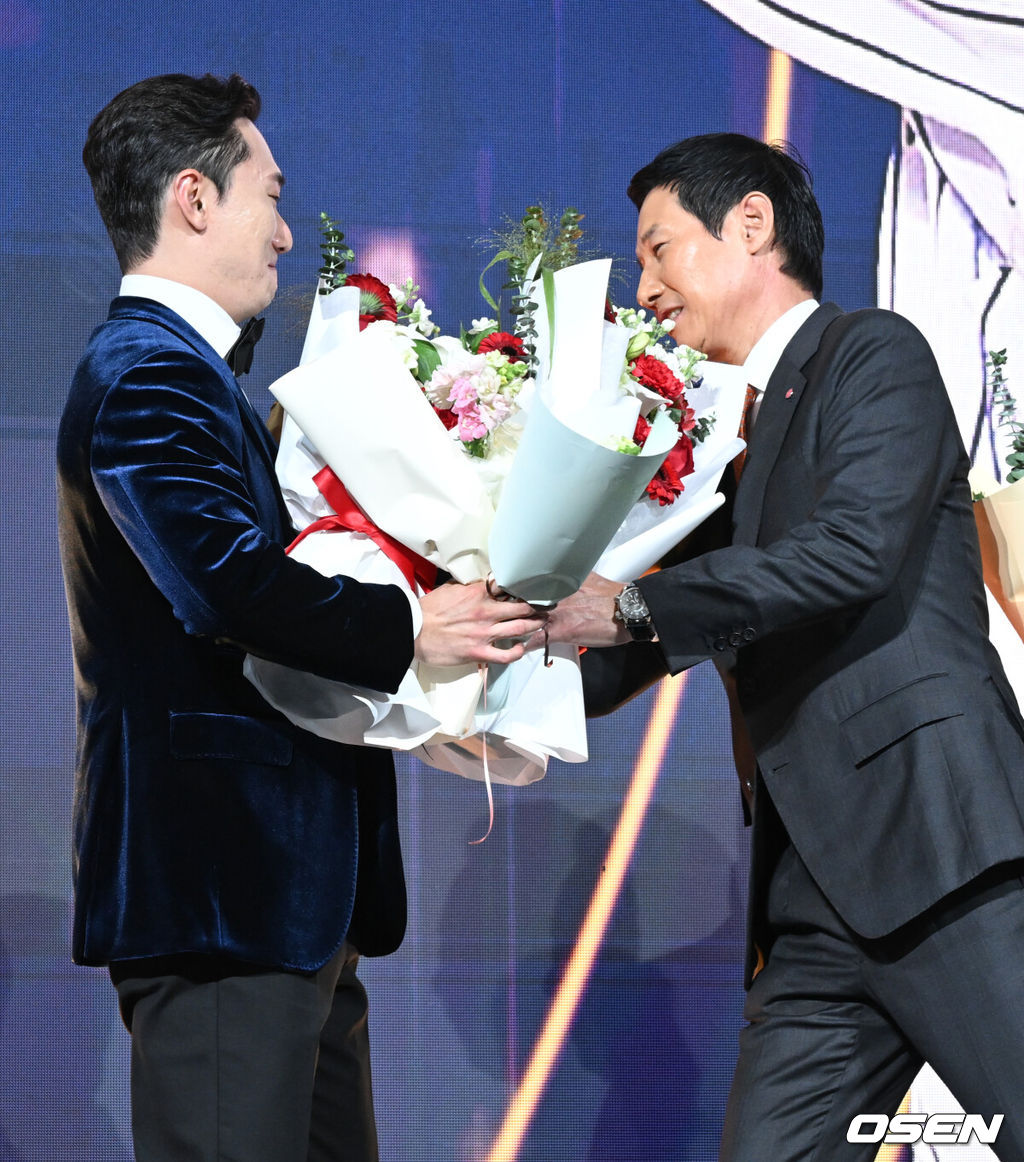 9일 오후 서울 송파구 잠실동 롯데호텔 월드에서 2025 신한은행 SOL 뱅크 KBO 골든글러브 시상식이 열렸다.KBO 골든글러브 시상식은 포지션별 최고의 선수를 가리는 자리로 올 시즌의 대미를 장식하는 자리다. 2루수 부문을 수상한 LG 신민재가 염경엽 감독에게 꽃다발을 받고 있다. 2025.12.09 /cej@osen.co.kr