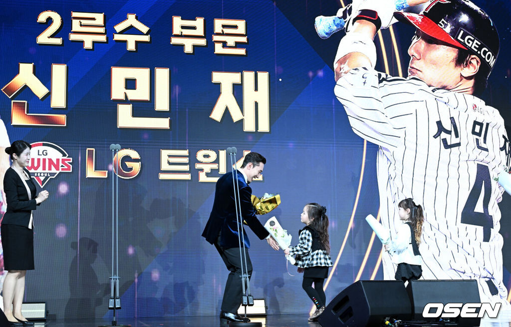 9일 오후 서울 송파구 잠실동 롯데호텔 월드에서 2025 신한은행 SOL 뱅크 KBO 골든글러브 시상식이 열렸다.KBO 골든글러브 시상식은 포지션별 최고의 선수를 가리는 자리로 올 시즌의 대미를 장식하는 자리다. 2루수 부문을 수상한 LG 신민재가 딸에게 꽃다발을 받고 있다. 2025.12.09 /cej@osen.co.kr