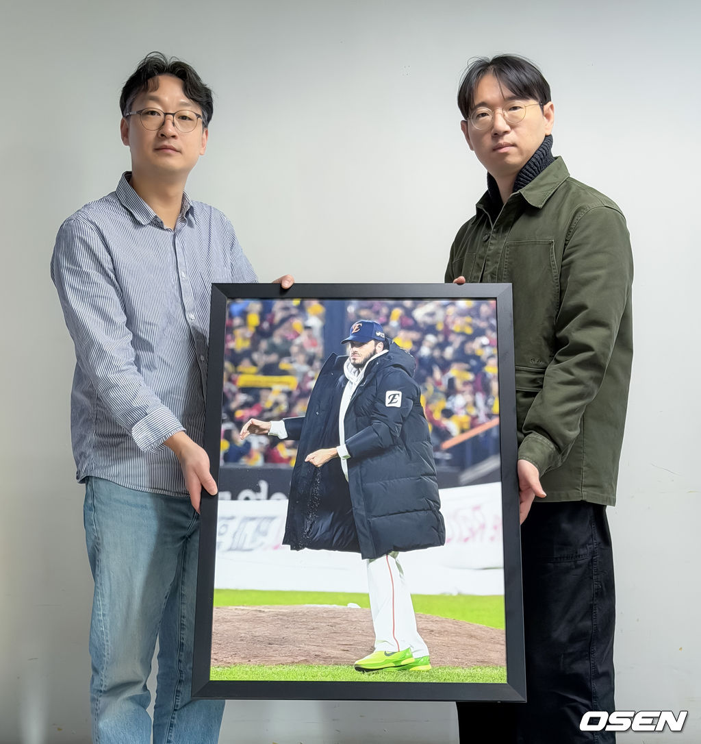 한국스포츠사진기자회 지형준 회장(오른쪽)과 '2025 올해의 야구 보도사진상'을 촬영한 OSEN 이대선 기자가 수상작과 함께 포즈를 취하고 있다. <사진제공=스포츠사진기자회>