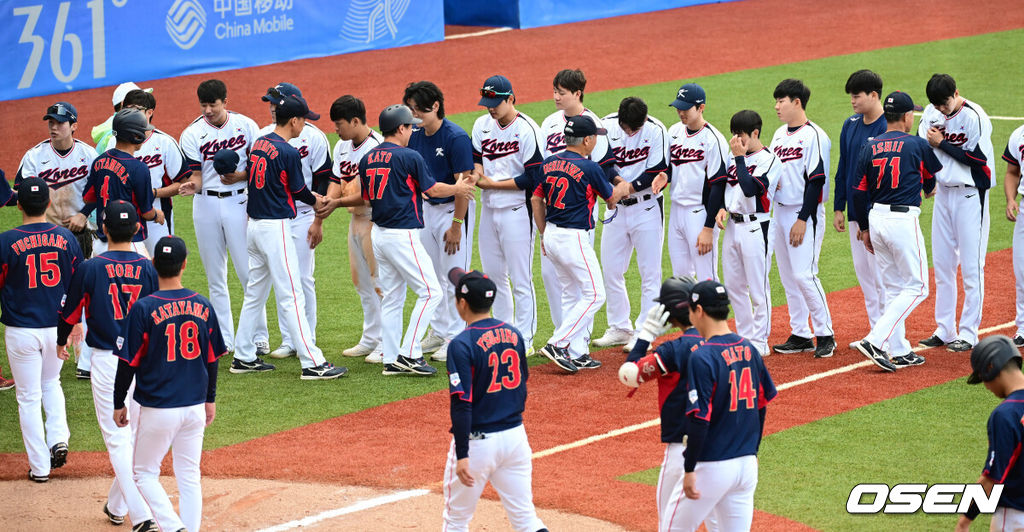 한국이 숙적 일본을 꺾고 슈퍼라운드 1차전을 승리로 장식했다. 한국은 5일(이하 한국시간) 중국 저장성 사오싱 야구장에서 열린 2022 항저우 아시안게임 슈퍼라운드 일본전에서 2-0으로 이겼다. 선발 박세웅의 완벽투를 앞세워 승리를 거머쥐었다. 경기를 마치고 양 팀 선수들이 인사를 나누고 있다. 2023.10.05 / dreamer@osen.co.kr