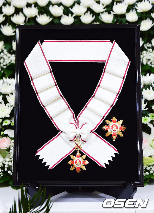 [OSEN=사진팀] 정부가 5일 별세한 배우 고(故) 안성기에게 문화훈장 최고 등급인 금관문화훈장을 추서했다. 문화예술 발전과 국민의 문화 향유에 기여한 공적을 기리기 위한 조치로, 문화체육관광부 최휘영 장관은 정부를 대표해 훈장을 전했다.이번 금관문화훈장은 2005년 보관문화훈장(3등급), 2013년 은관문화훈장(2등급)에 이은 세 번째 훈장이었다. 60여 년에 걸쳐 한국영화의 성장과 도약을 이끈 공로를 공식적으로 기리는 의미가 담겼다.안성기는 1957년 영화 ‘황혼열차’로 데뷔한 이후 ‘바람 불어 좋은 날’, ‘고래사냥’, ‘투캅스’, ‘실미도’, ‘화려한 휴가’, ‘한산: 용의 출현’ 등 130여 편에 출연하며 세대를 아우르는 연기를 남겼다. 특히 ‘실미도’를 통해 한국영화 최초 천만 관객 시대를 열며 대중성과 산업적 성장을 상징하는 배우로 평가받았다.대종상·청룡·백상 등 주요 시상식에서 다수의 상을 수상한 그는 ‘국민 배우’로 한국영화와 생애를 함께했다. 고인은 이날 오전 9시 서울 용산구 순천향대병원 중환자실에서 가족이 지켜보는 가운데 별세했으며, 장례는 영화인장으로 치러졌다. 빈소는 서울성모병원 장례식장에 마련됐고 발인은 9일 오전 6시 엄수됐다. / photo@osen.co.kr<사진=사진공동취재단>