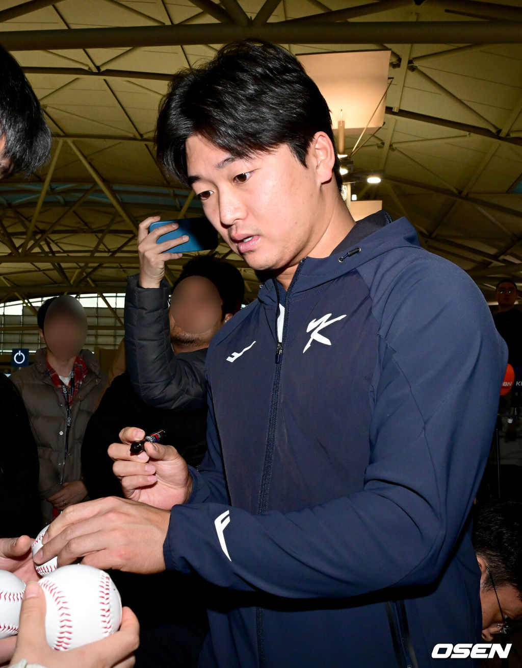 류지현 감독이 이끄는 한국 야구대표팀이 오는 3월 열리는 WBC를 준비하기 위해 9일 오전 인천공항을 통해 미국령 사이판으로 출국했다.류지현호는 9일부터 21일까지 사이판에서 1차 전지훈련 담금질에 나선다.대표팀 고우석이 팬들의 사인 요청에 응하고 있다. 2026.01.09 / dreamer@osen.co.kr