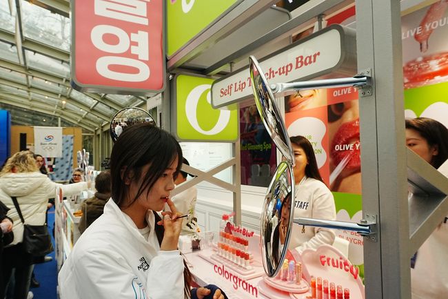 스노보드 하프파이프 금메달 최가온이 밀라노 코리아하우스 ‘올리브영’ 부스에서 립 제품을 테스트하고 있다. /CJ그룹 제공.&nbsp;