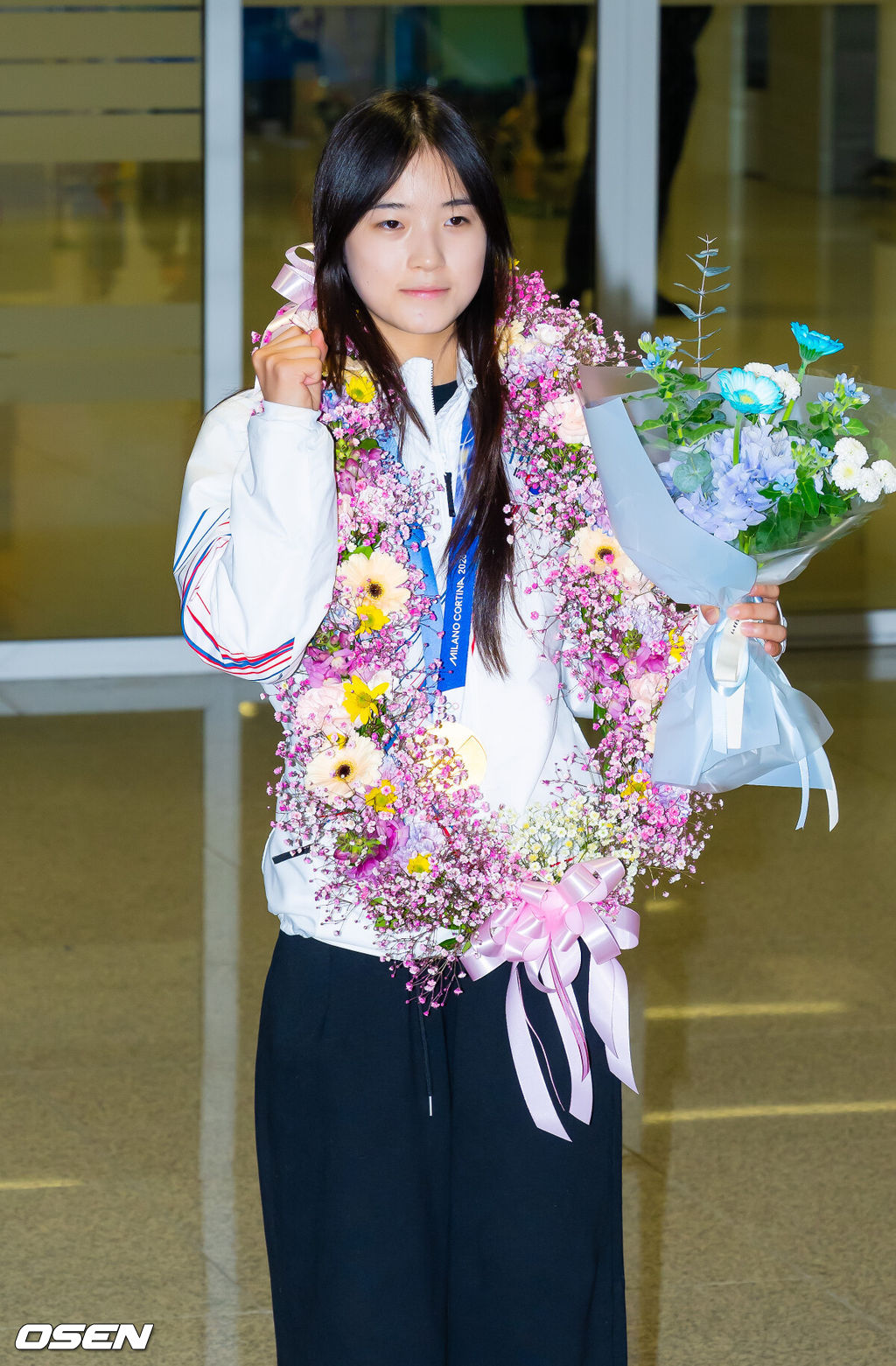 밀라노·코르티나담페초 동계올림픽 우리 선수단 첫 금메달의 주인공 최가온(18·세화여고)이 16일 오후 인천국제공항을 통해 입국했다.최가온은 지난 13일 밀라노 아이스스케이팅 아레나에서 열린 여자 스노보드 하프파이프 결선에서 극적인 역전 드라마를 완성하며 한국 선수단의 설상 종목 첫 올림픽 금메달의 주인공이 됐다.최가온이 입국장을 걸어 나온 후 금메달을 들고 포즈를 취하고 있다. 2026.02.16 /rumi@osen.co.kr