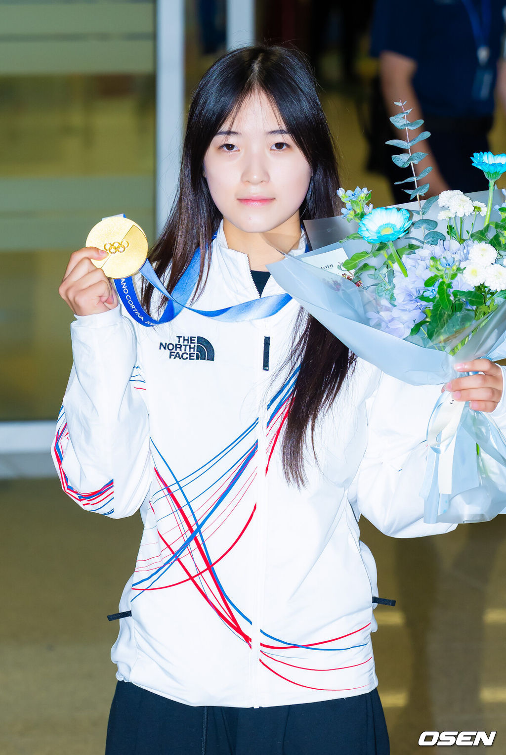 밀라노·코르티나담페초 동계올림픽 우리 선수단 첫 금메달의 주인공 최가온(18·세화여고)이 16일 오후 인천국제공항을 통해 입국했다.최가온은 지난 13일 밀라노 아이스스케이팅 아레나에서 열린 여자 스노보드 하프파이프 결선에서 극적인 역전 드라마를 완성하며 한국 선수단의 설상 종목 첫 올림픽 금메달의 주인공이 됐다.최가온이 입국장을 걸어 나온 후 금메달을 들고 포즈를 취하고 있다. 2026.02.16 /rumi@osen.co.kr