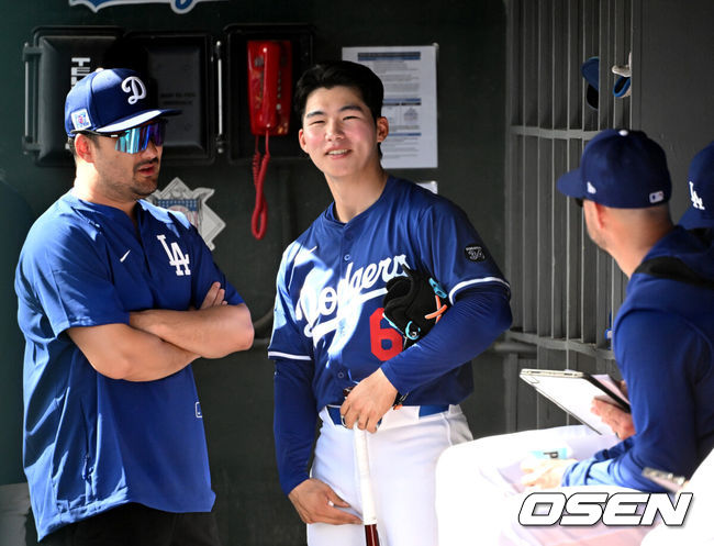 [OSEN=애리조나(미국), 이대선 기자] 21일(한국시간) 미국 애리조나주 글렌데일 캐멀백 랜치에서 2025 메이저리그 LA 다저스와 시카고 컵스의 시범 경기가 열렸다.김혜성은 다저스와 최대 3+2년 2200만 달러(약 320억원) 계약에 합의하며 메이저리그 진출에 성공했다.LA 다저스 김혜성이 더그아웃에서 미소를 짓고 있다.  2025.02.21 / sunday@osen.co.kr