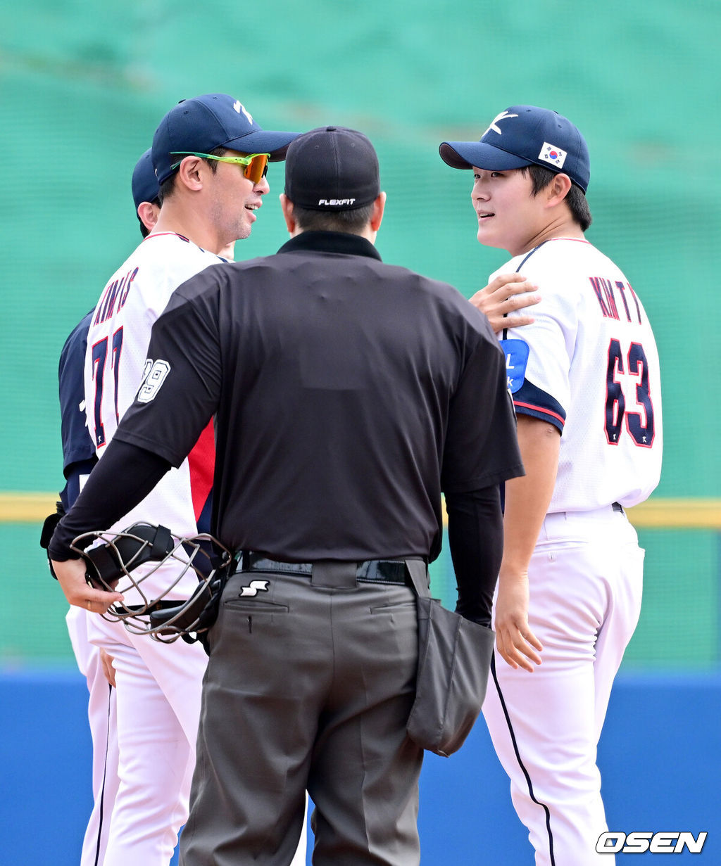 2026 WBC(월드베이스볼클래식)를 준비하는 대한민국 야구 대표팀이 24일 일본 오키나와 가데나 야구장에서 프로야구 KIA 타이거즈와 연습경기를 펼쳤다. 야구 대표팀은 오키나와에서 국내 팀들과 6차례 연습경기를 치르며 전력을 끌어올릴 예정이다.5회초 1사 주자없는 상황 KIA 데일의 강습타구를 처리한 대표팀 투수 김택연이 김광삼 코치와 대화를 나누고 있다. 2026.02.24 / dreamer@osen.co.kr